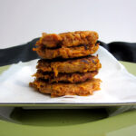 A stack of five sweet potato fritters on a white plate.