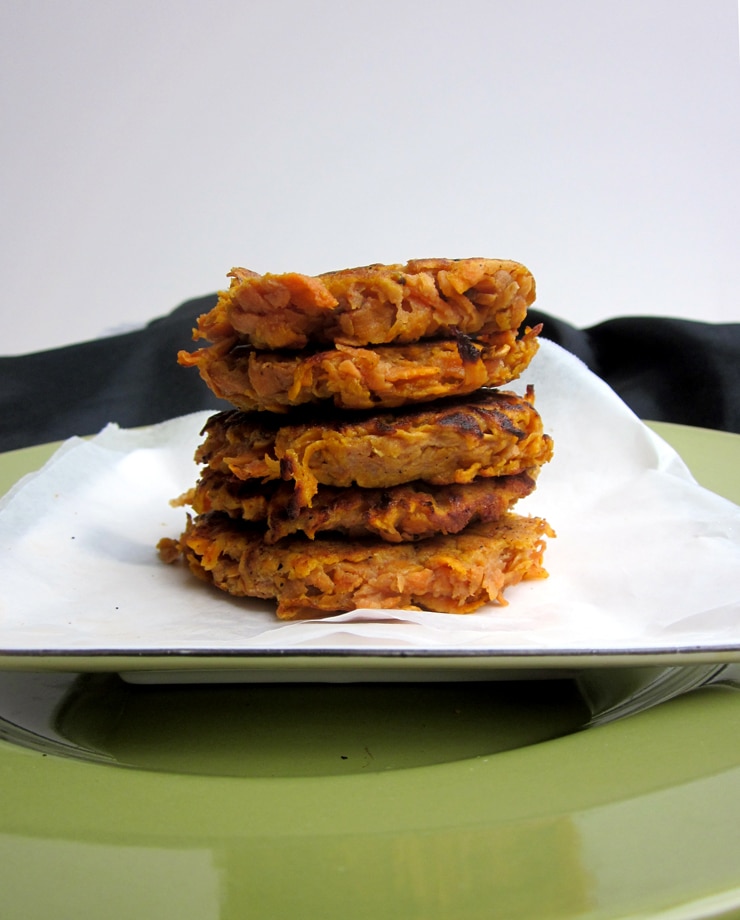 A stack of five sweet potato fritters on a white plate.