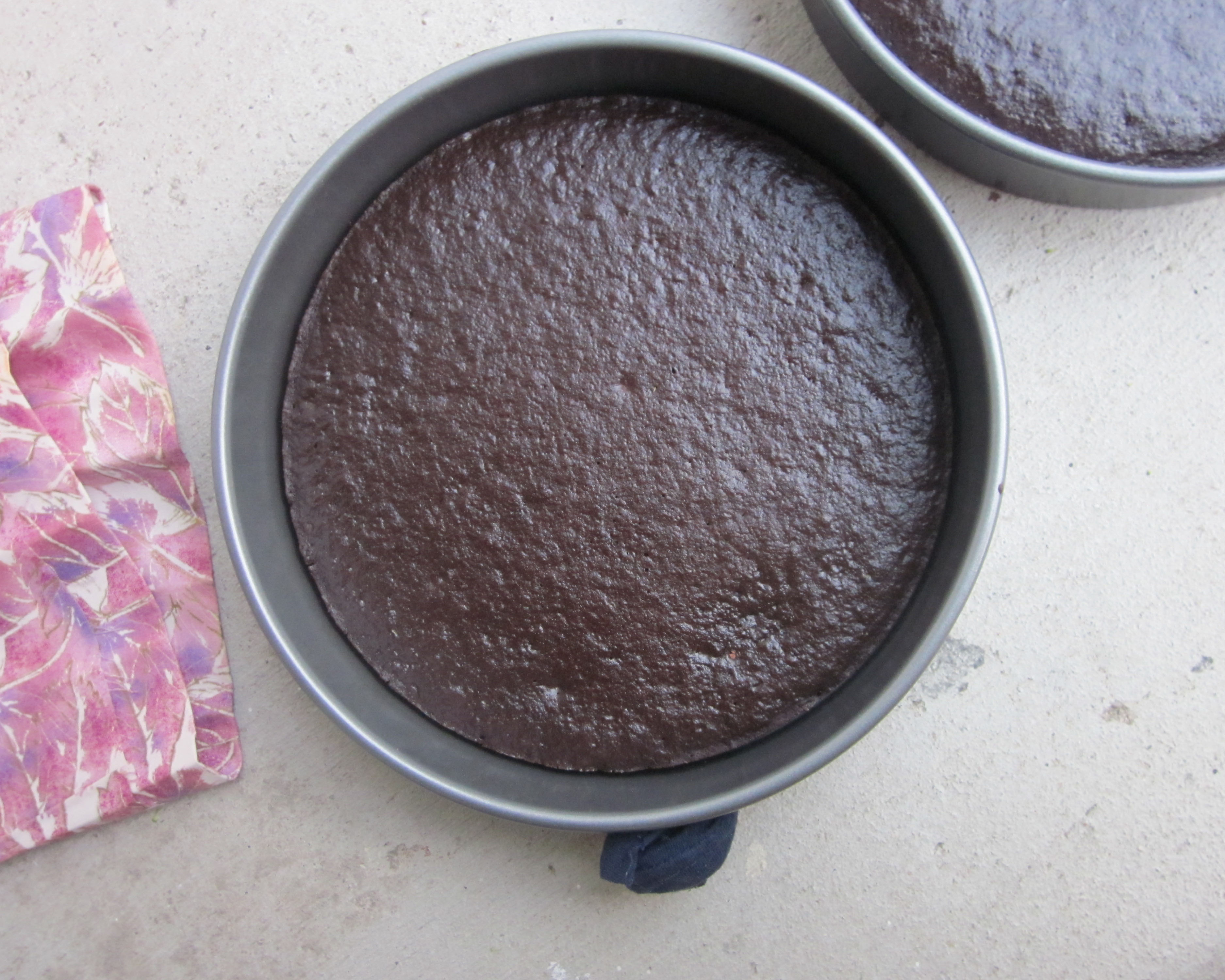 A round cake pan filled with chocolate cake.