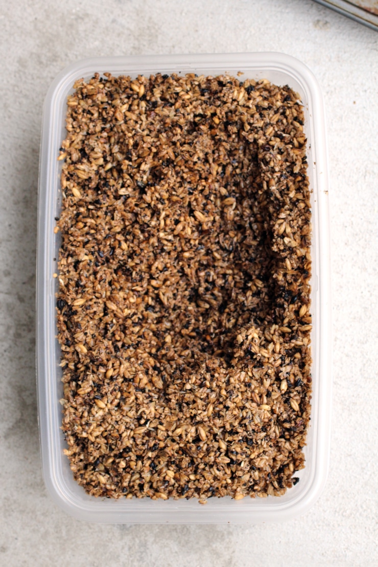 A plastic container full of spent grain.