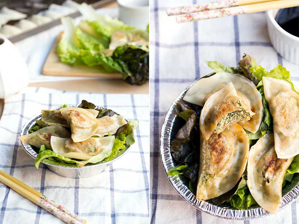 Tofu kale potstickers on top of lettuce in a silver bowl.