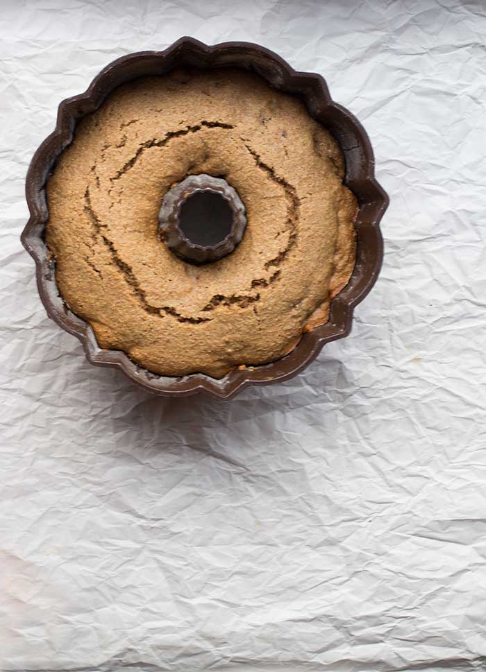 A bundt cake pan full of cake on a white background.