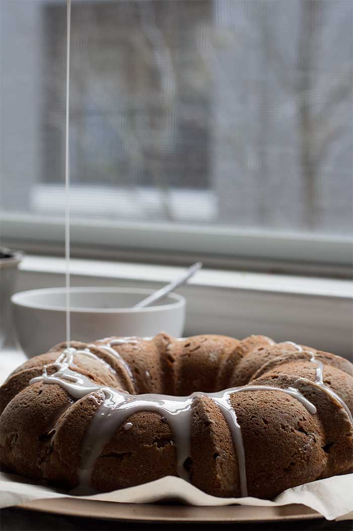 Close up on a apple bundt cake with icing drizzled on top.
