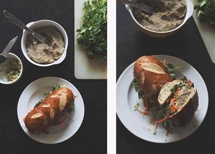 An assembled banh mi on a white plate next to a bowl of lentil pate.