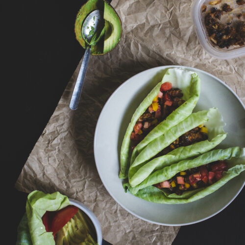 Cabbage wraps filled with chickpea taco meat on a white plate.