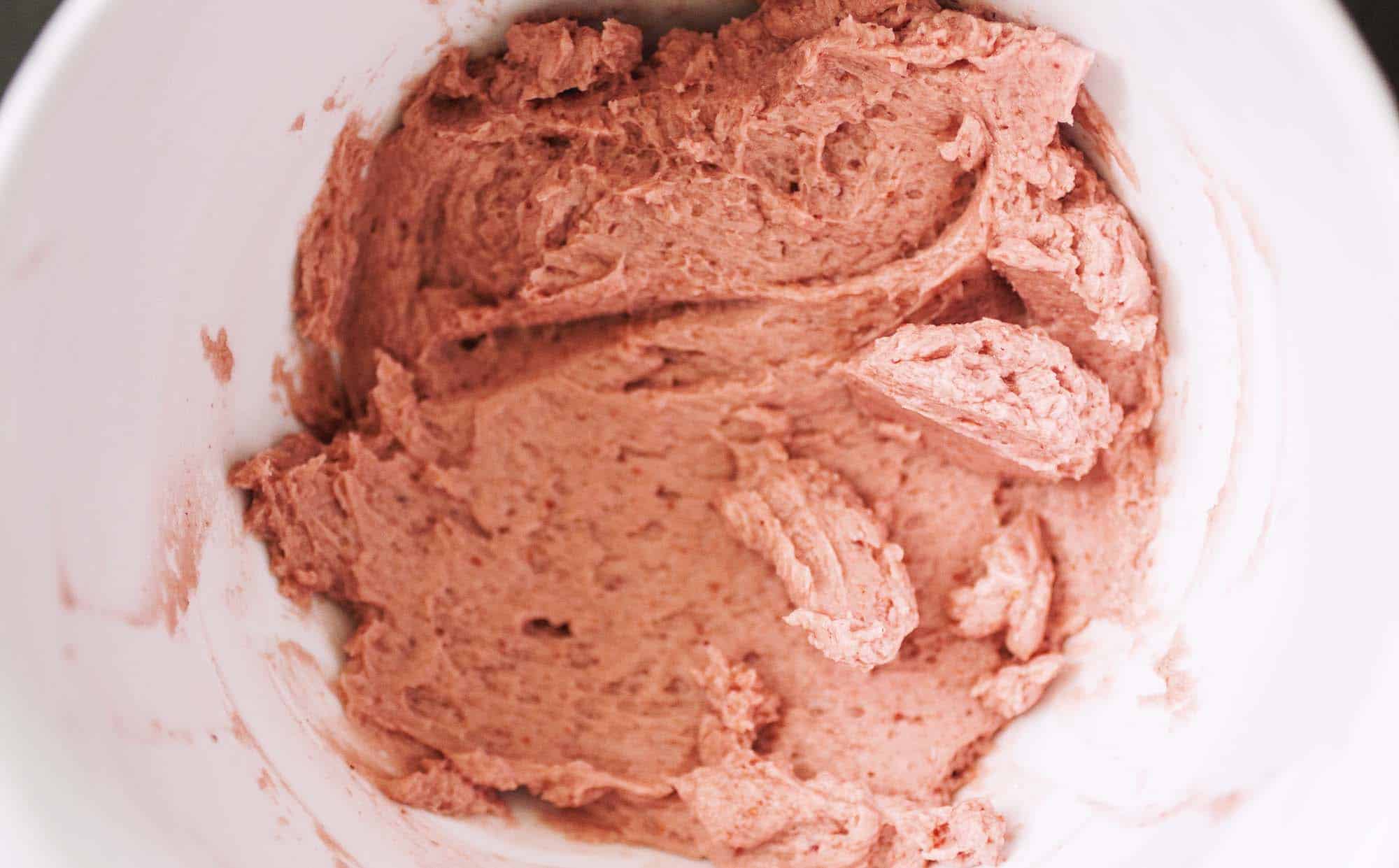 A bowl of strawberry frosting.
