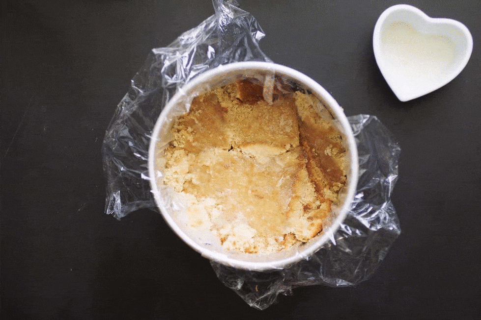 A gif of assembling a strawberry lemon milk bar-style cake with jam, cake, and crumbles.