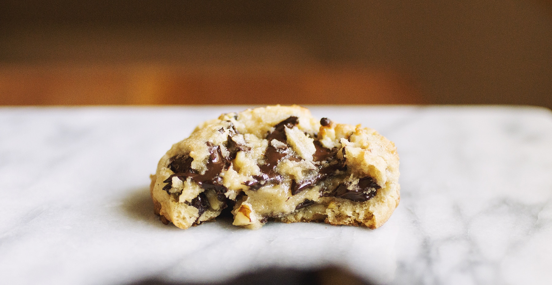 Half of a chocolate chip Levain copycat cookie on a marble background.