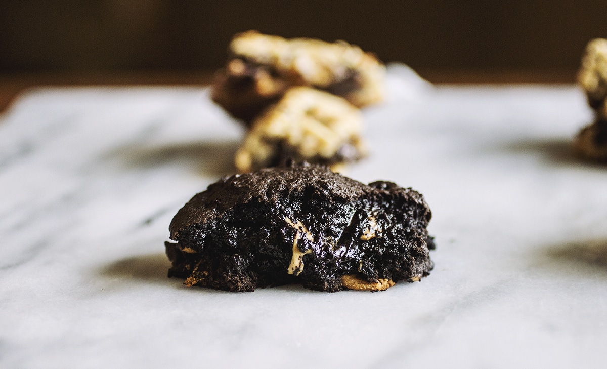 Half of a chocolate peanut butter Levain copycat cookie on a marble background.