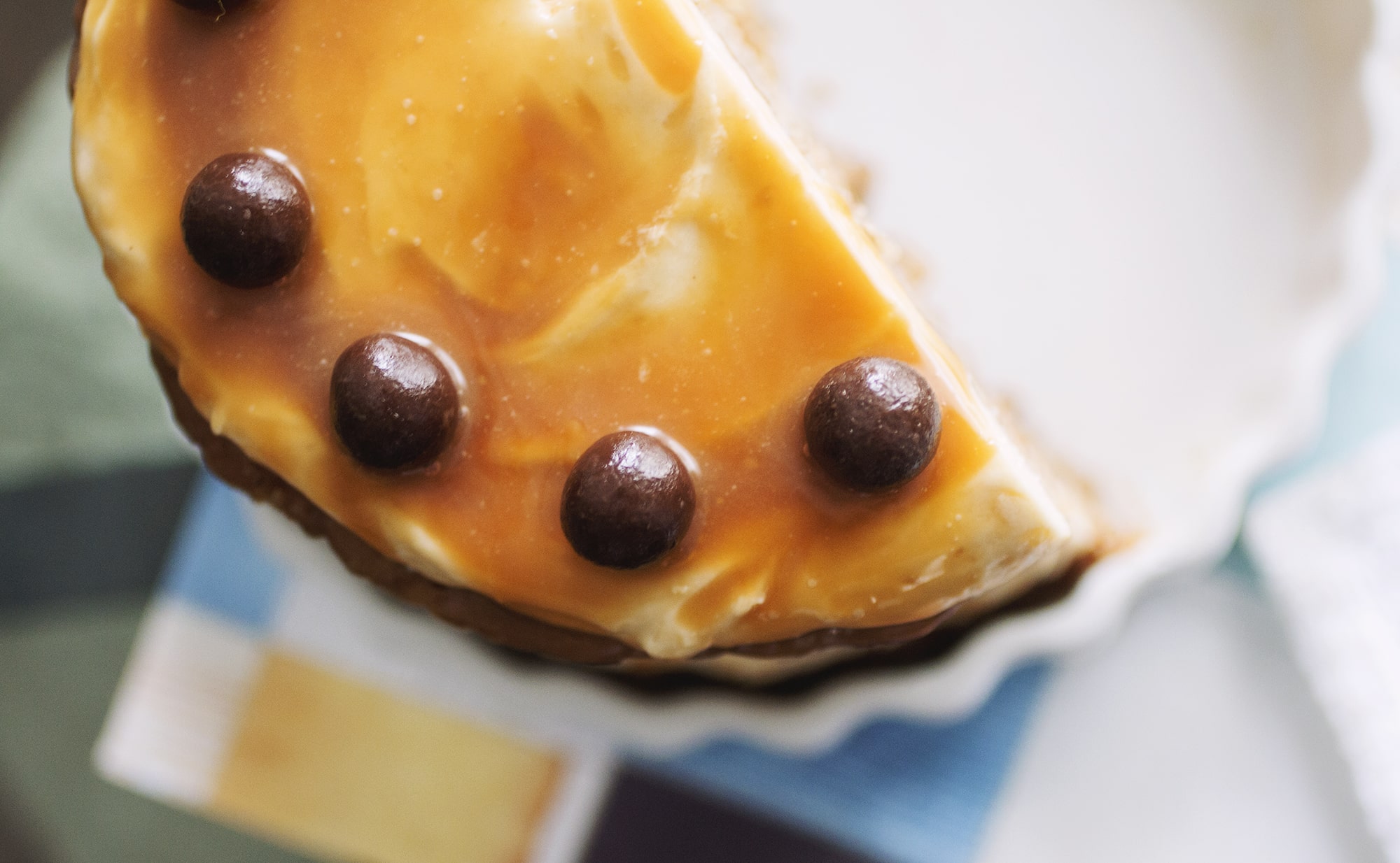 Close up on the chocolate balls on top of a caramel apple cake.