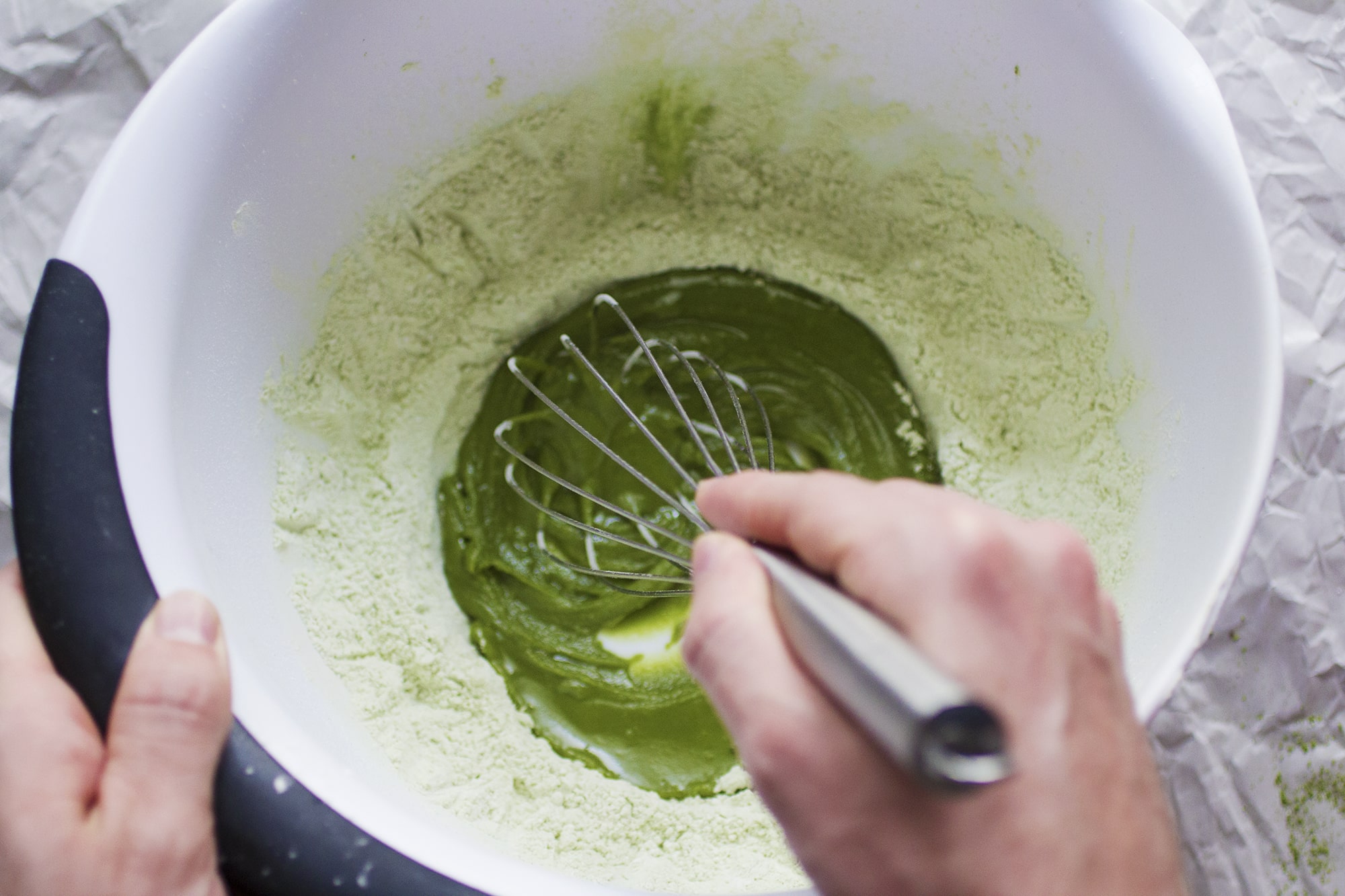 A bowl full of matcha being whisked.
