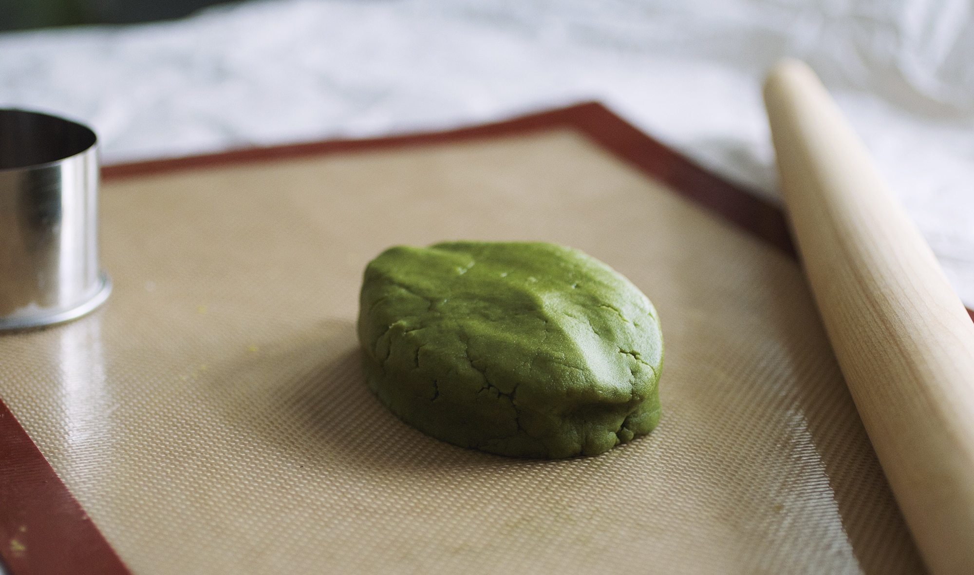 A vibrant block of matcha dough on a silpat mat.