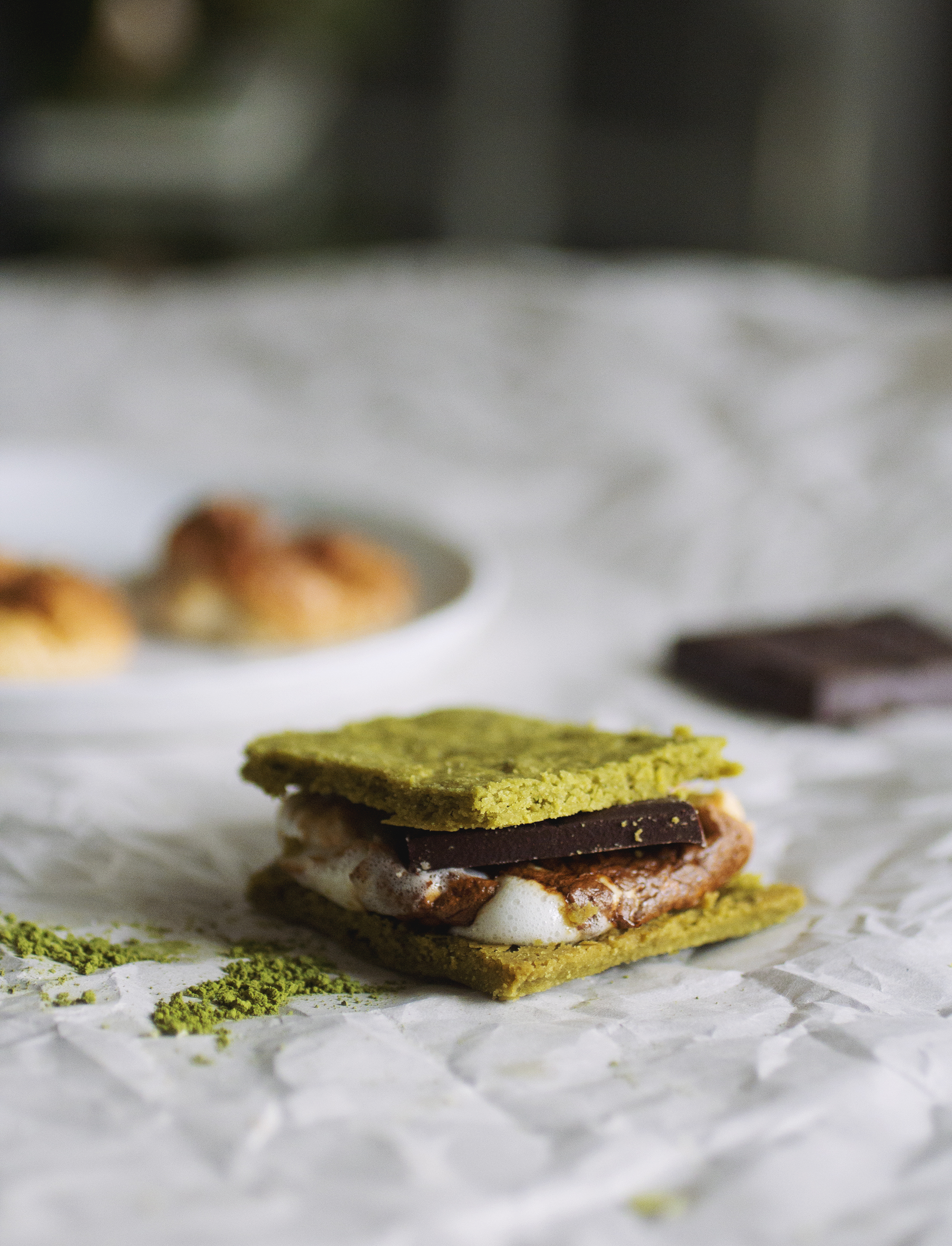 A matcha s\'mores on white parchment paper.