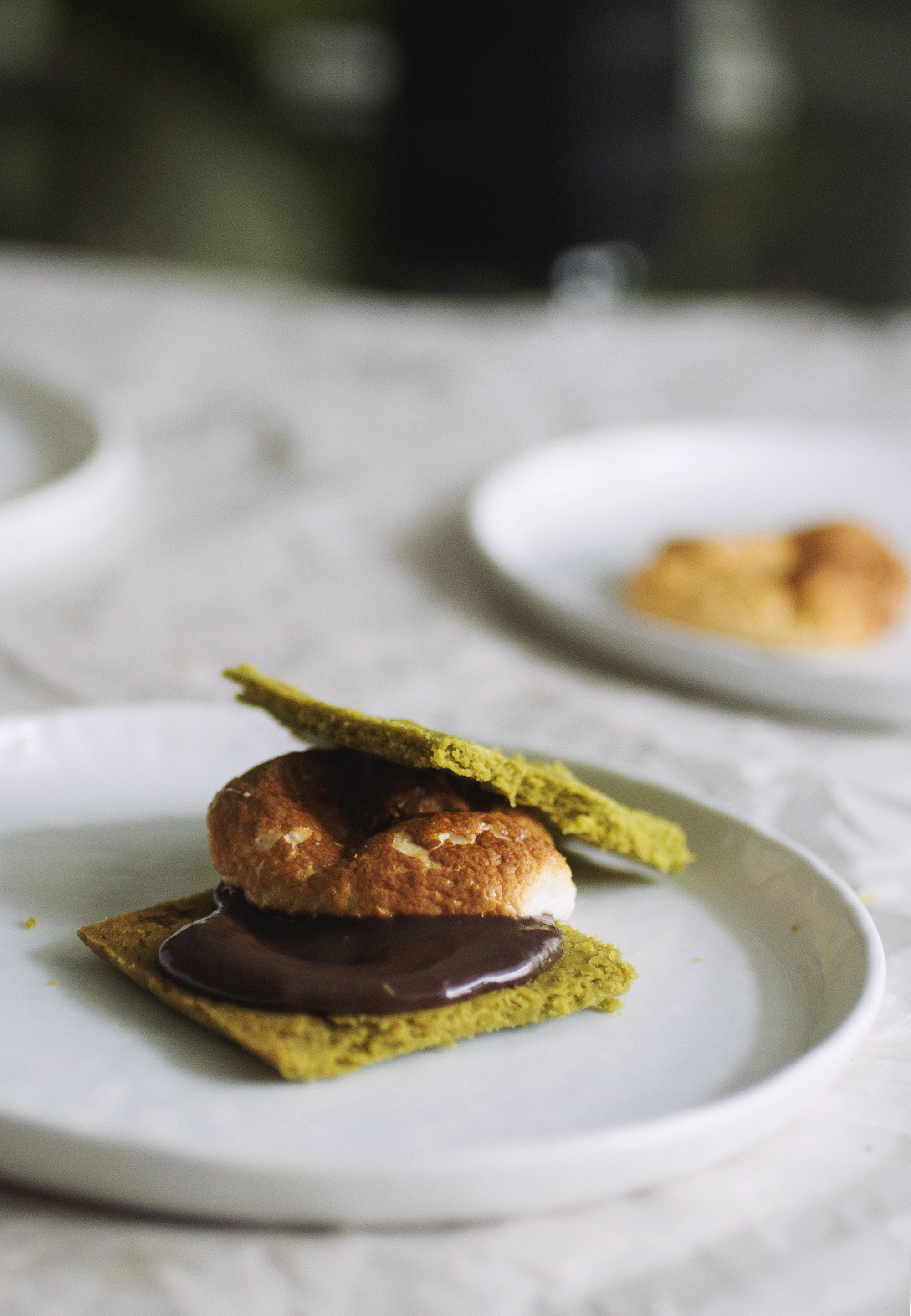 A matcha s\'more on a white plate.