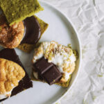 Three open-faced matcha s'mores on a white plate.