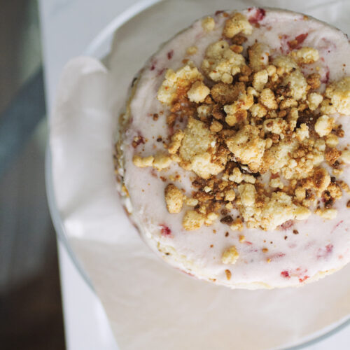A triple strawberry cake with tons of milk crumbs on the top.