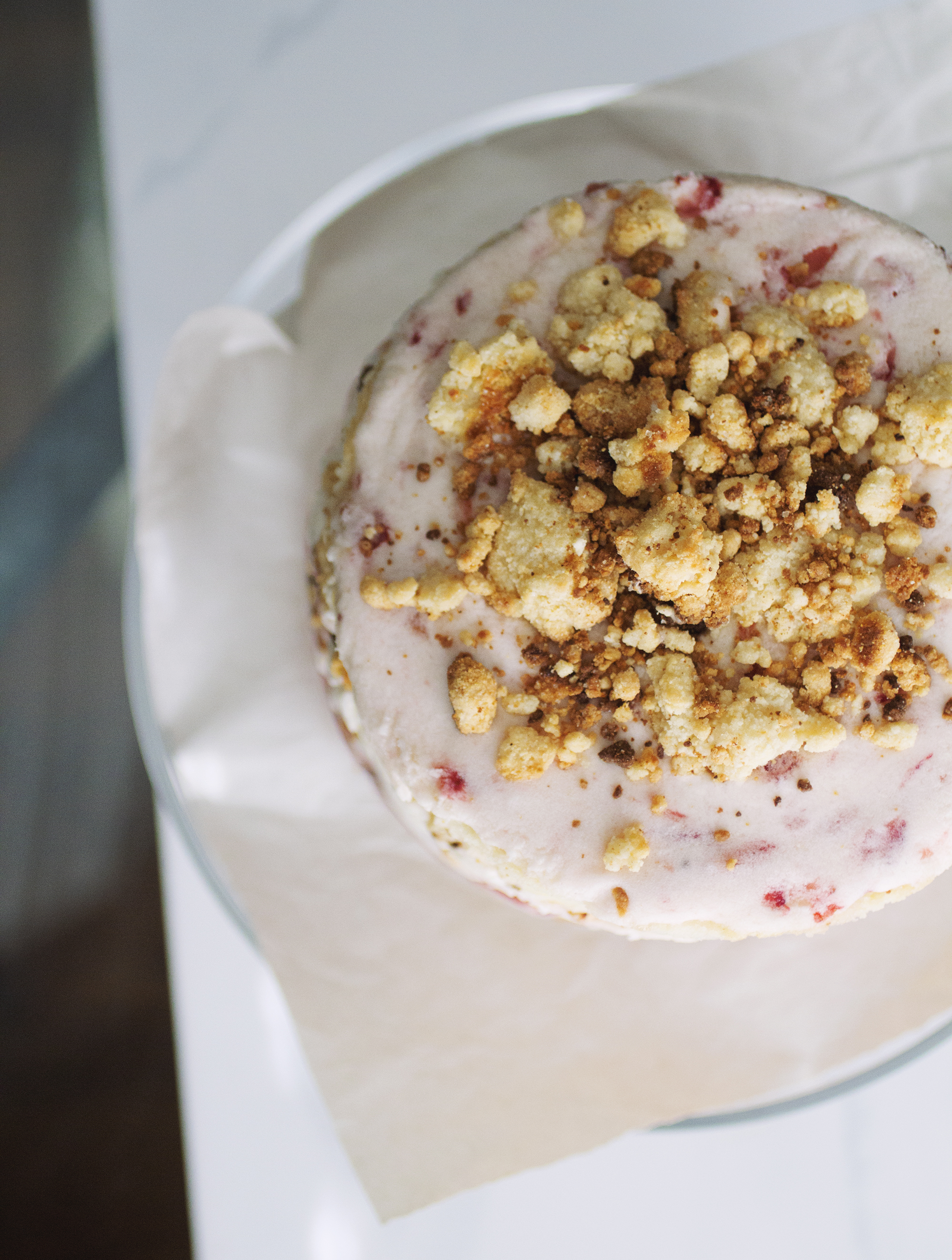 A triple strawberry cake with tons of milk crumbs on the top.