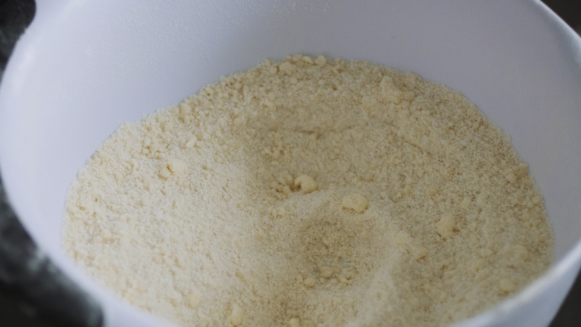 Powdered milk crumbs in a white bowl.