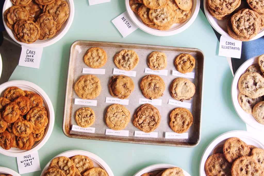12 different chocolate chip cookies on a baking sheet with labels.