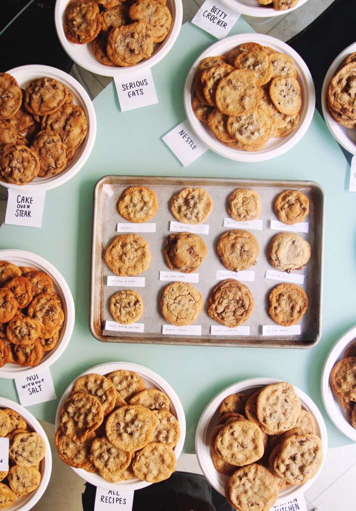 12 different chocolate chip cookies on a sheet pan.