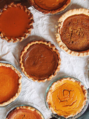 9 different pumpkin pies on a table.