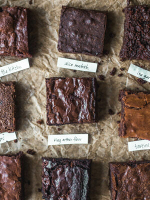 9 different squares of brownies on a sheet of parchment.