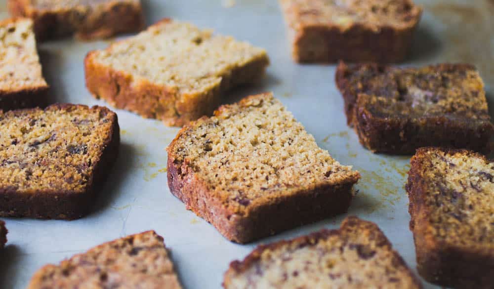 A half slice of banana bread on a silver tray.