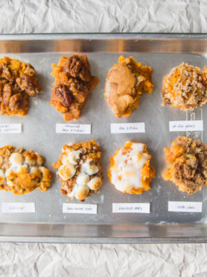 8 scoops of different sweet potato casseroles on a silver tray.