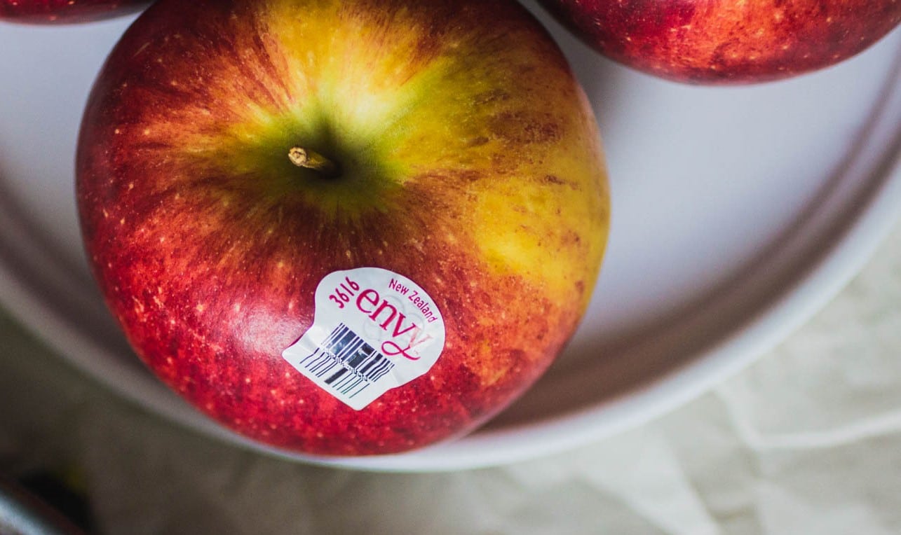 Close up on an apple with an Envy sticker.