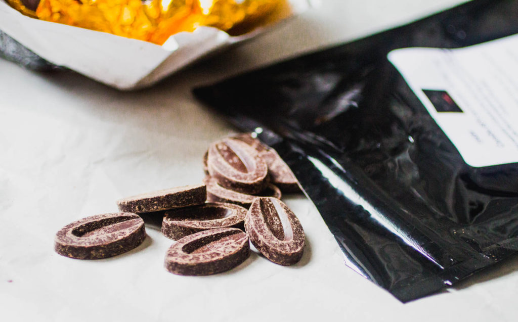 Close up on a black bag overflowing with Valrhona chocolate feves.
