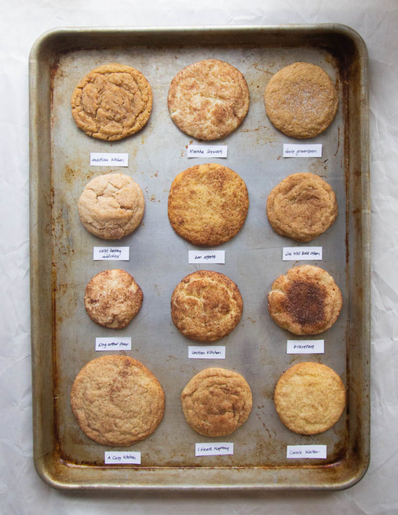 12 different snickerdoodles on a gray baking sheet.