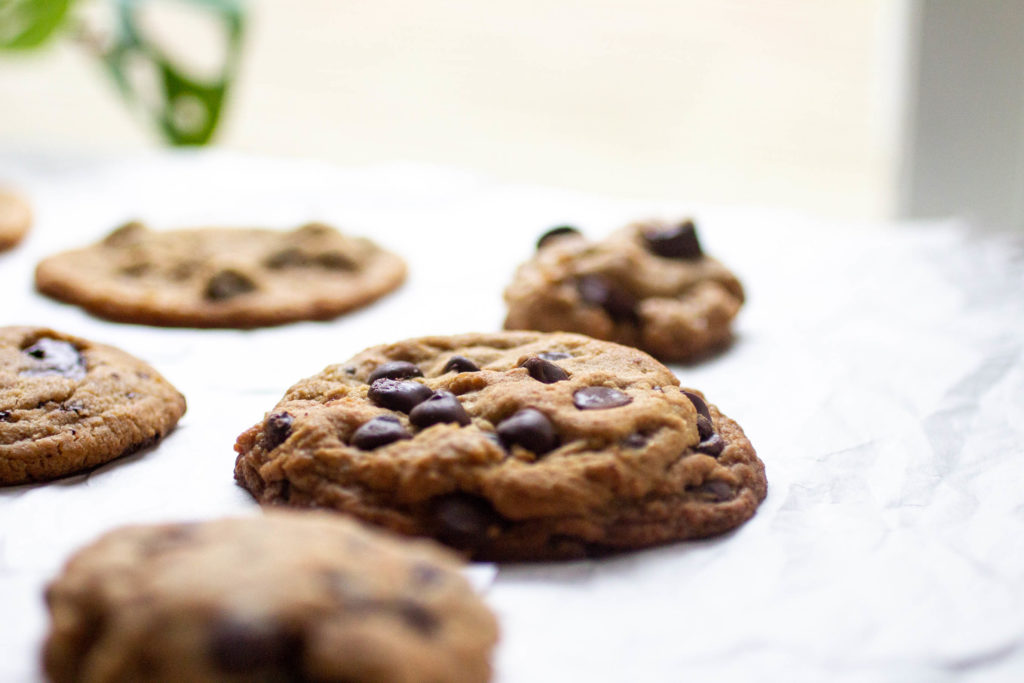 A close up on a thick chocolate chip cookie with lots of chips.
