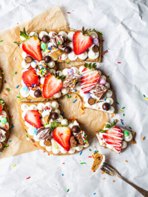 birthday cookie cake shaped like the numbers 35 topped with frosting, fruit and candy.