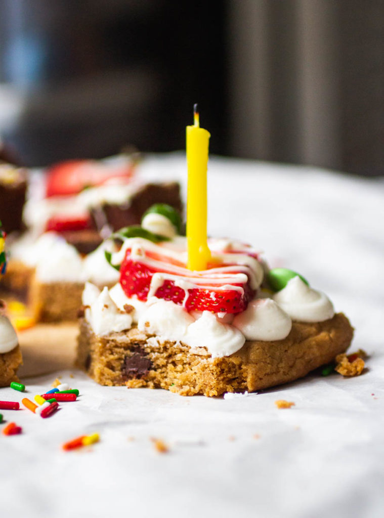 cookie cake with frosting, strawberries and a candle.