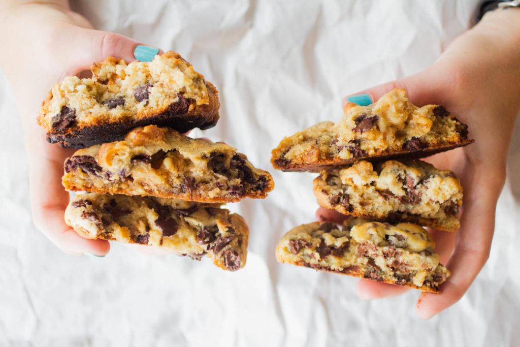 Two hands holding 6 halves of Levain copycat chocolate chip walnut cookies.
