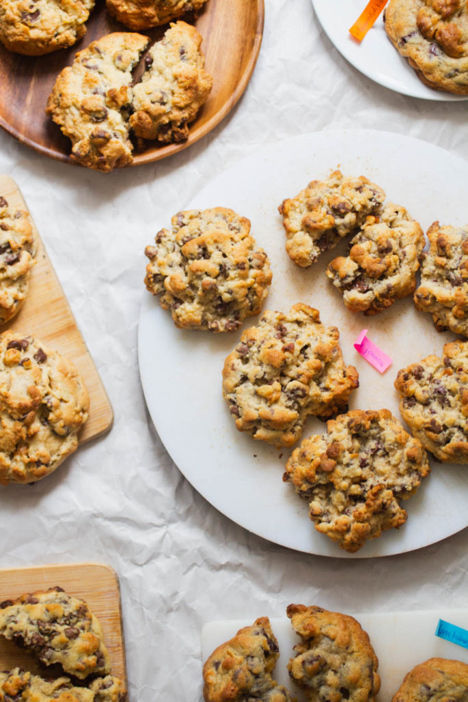 A round cutting board holding oversized Levain copycat cookies.