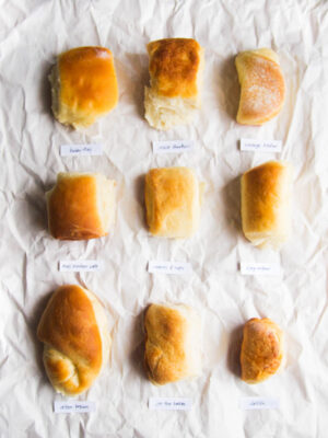 9 different parker house rolls on a gray background.