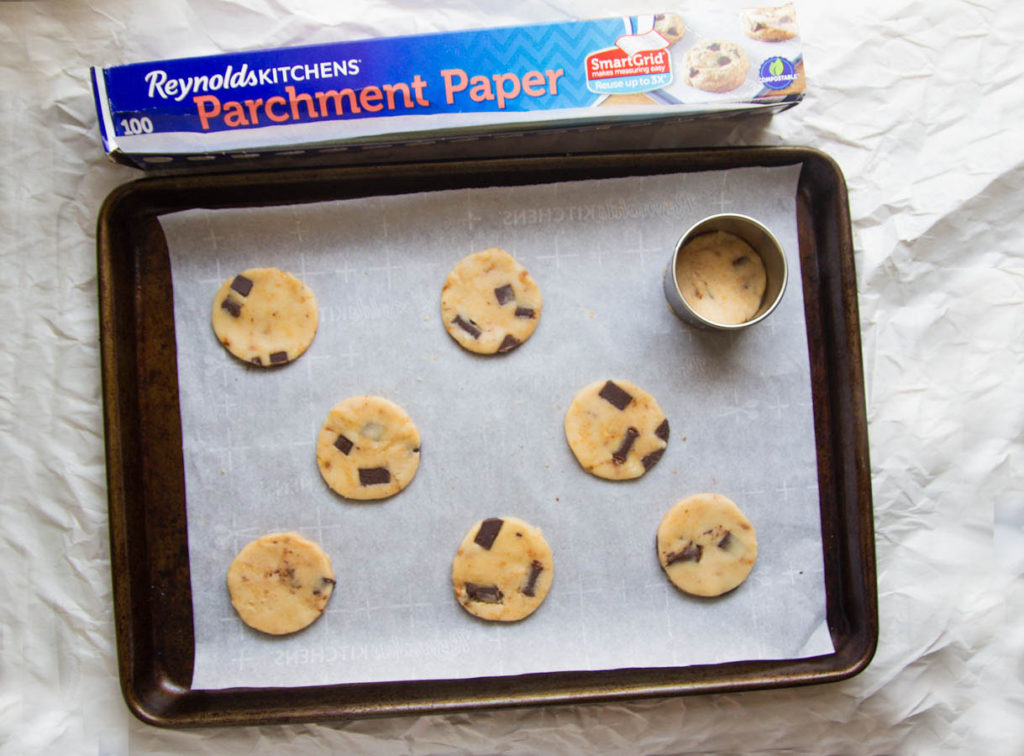 Rounds of cookie dough on a parchment-lined baking sheet.