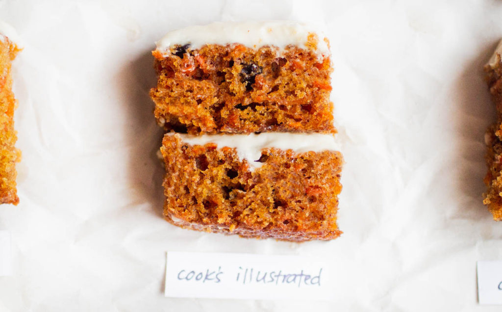 Slice of a doubled layered carrot cake on parchment paper - recipe by cook\'s illustrated.