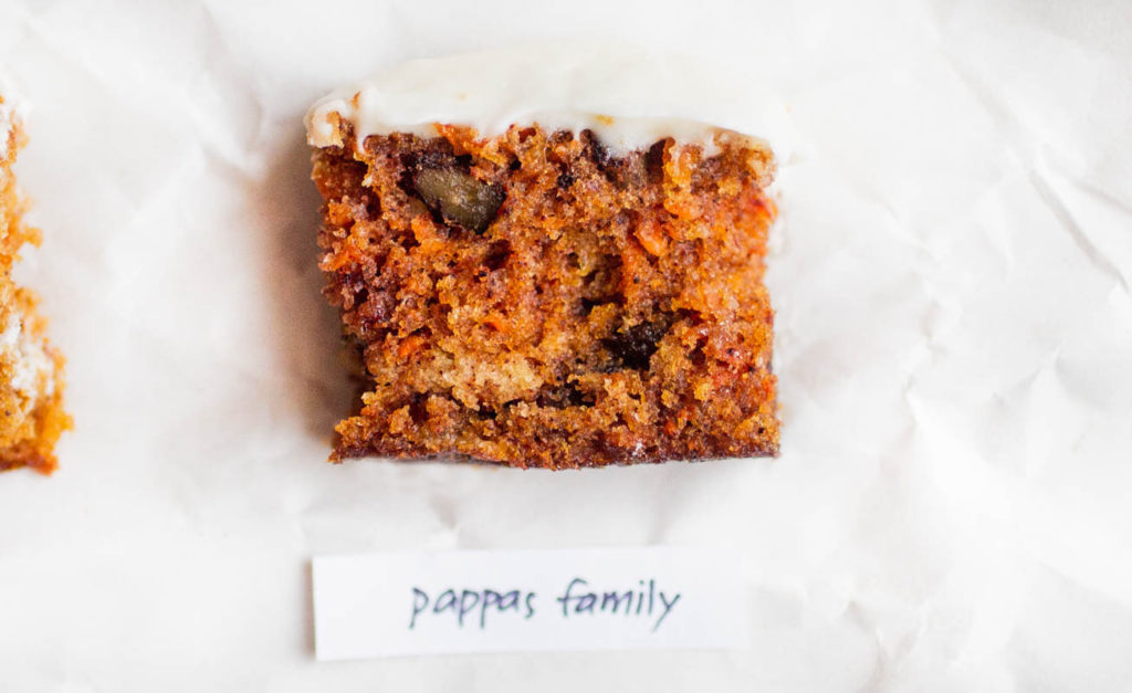 Single slice of pappas family carrot cake recipe on its side on parchment paper.