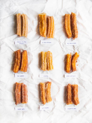 9 churros cut in half on a white background.