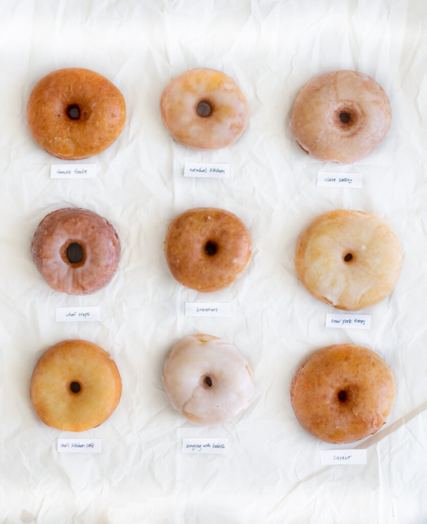9 different glazed donuts on a white background.