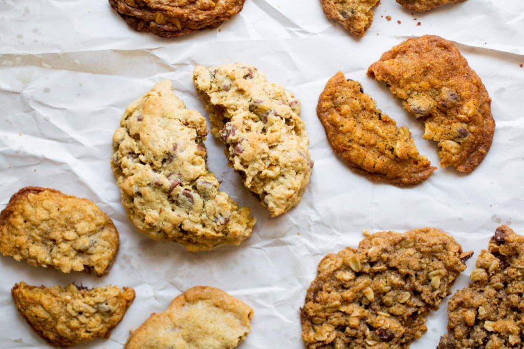 halves of oatmeal cookies on a white sheet.
