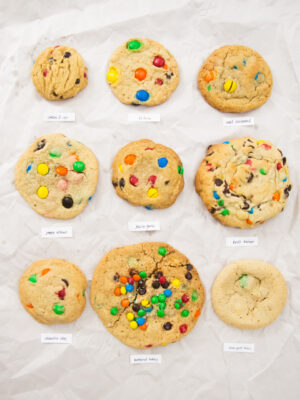 9 different M&M cookies on a white background.