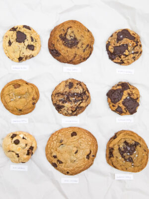 9 brown butter chocolate chip cookies on a white paper background.