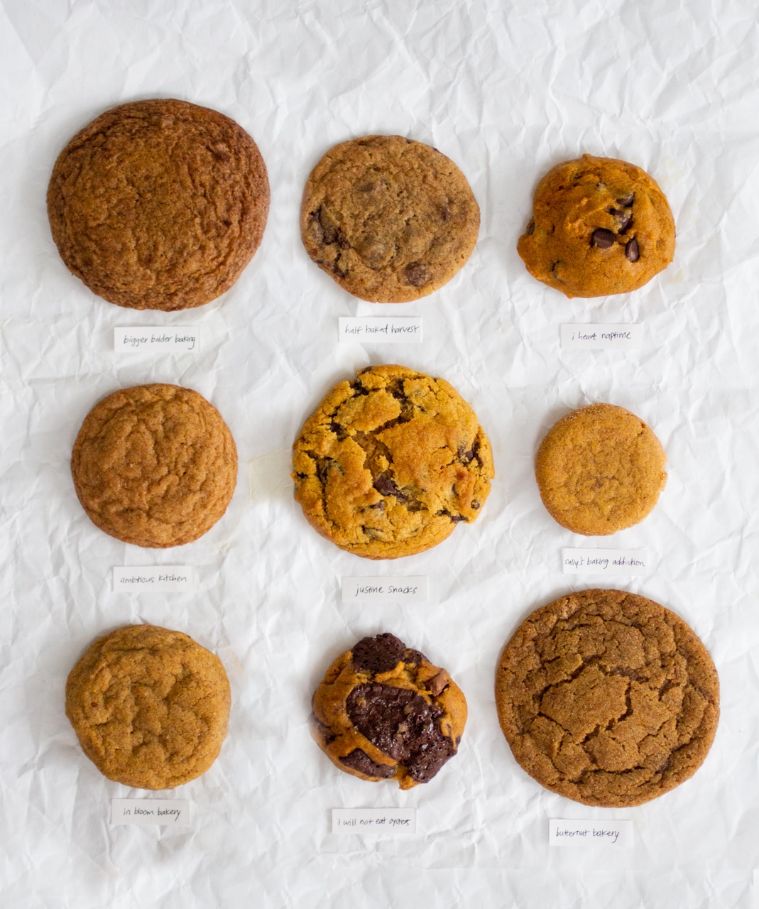 Overhead view of 9 slices of pumpkin cookies on white parchment for the best pumpkin cookie recipe bake off.