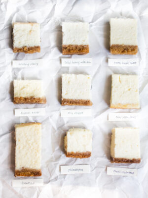 9 squares of cheesecake on a grey background.