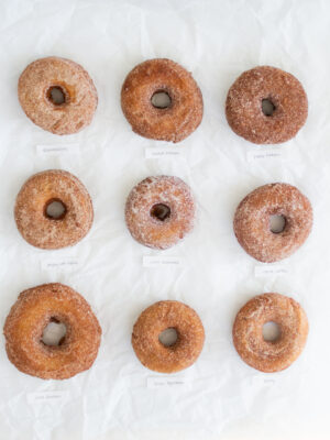 9 apple cider donuts on a white background.
