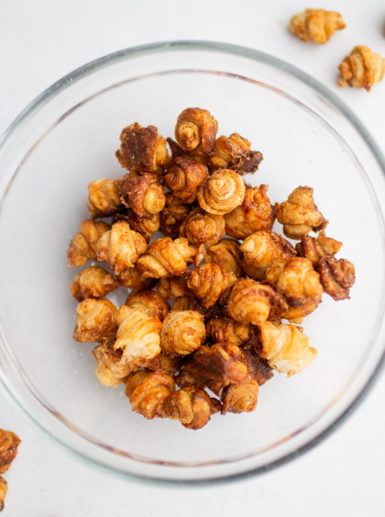 A glass bowl full of croissant cereal.