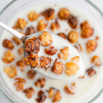a spoon with tiny croissant cereal in milk.